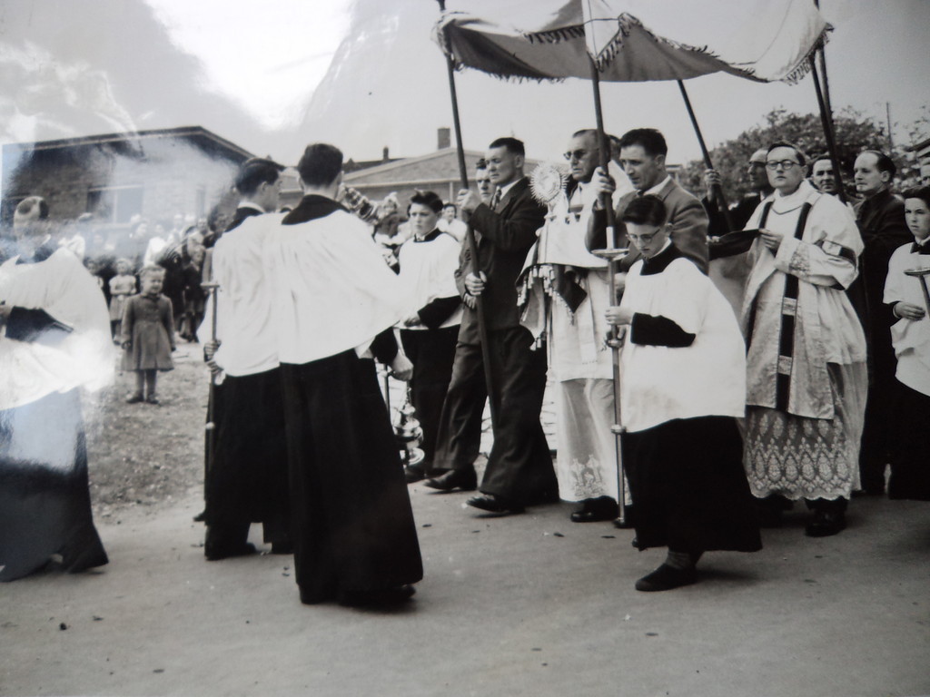 Clergy gathered beneath a canopy outdoors
